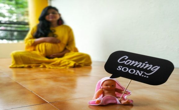 কোন বয়সে সন্তান নেয়ার সম্ভাবনা বেশি থাকে একজন প্রেগন্যান্ট মহিলা দেখাচ্ছে সামনে একটি পুতুল